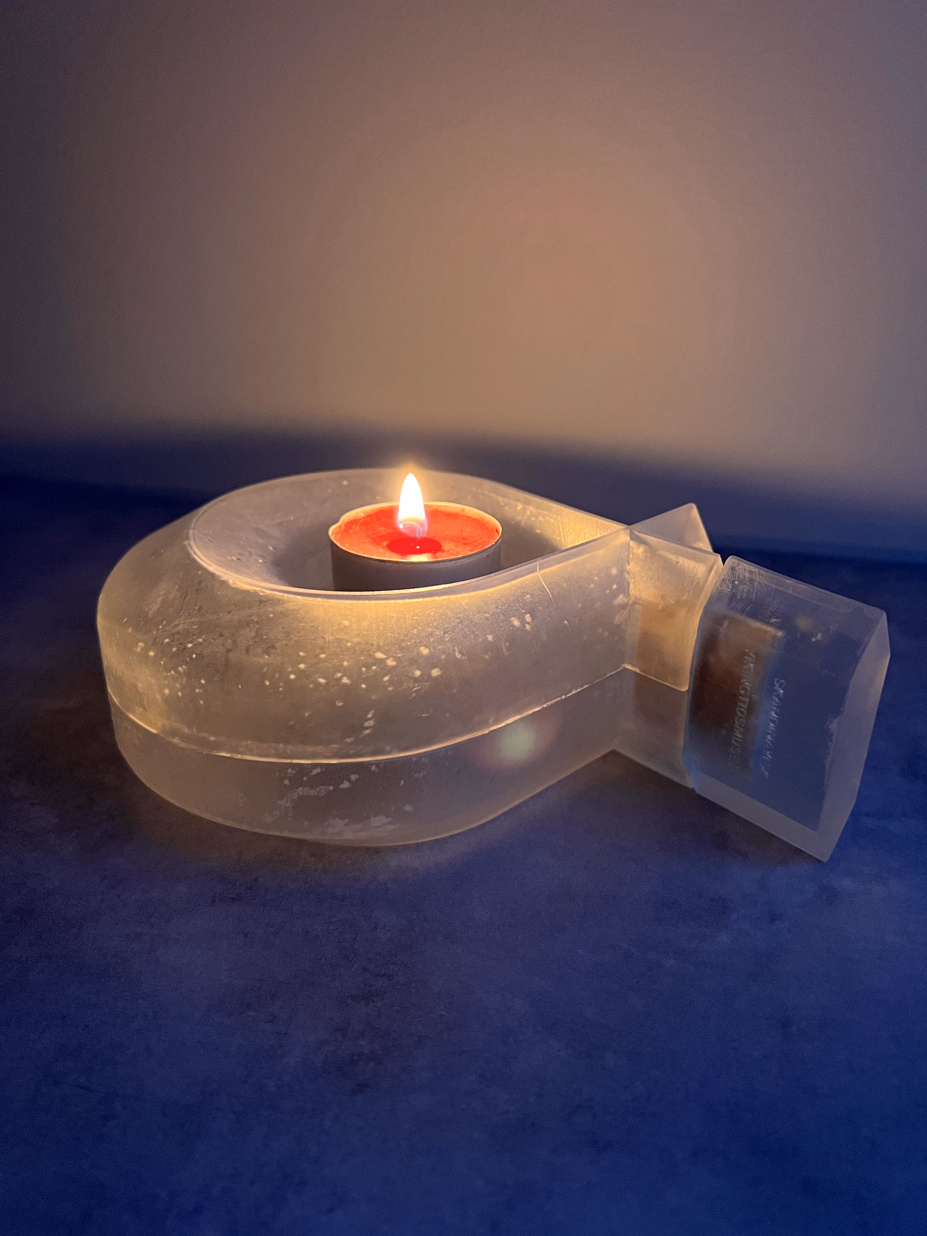 Transparent diffuser used as a candle holder with a lit candle